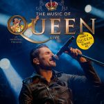 ein Mann hält ein Mikrofon und singt auf der Bühne, hinter ihm sind Scheinwerfer