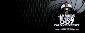 Werbeplakat für ‚James Bond 007 – Das Konzert‘ mit ikonischem Pistolenlauf-Design, einer Person im Smoking mit Waffe und dem Hinweis auf einen Gaststar aus den Filmen.
