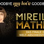 Eine lächelnde Frau auf dem schwarzen Hintergrund umhüllt von Goldenen Konfettis