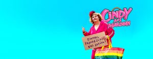 Eine Frau mit einer Tasche mit Regenbogenfarben und einem Schild