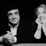 Ein schwarz-weiß Bild mit einem Mann und einer Frau, welche nachdenklich schauen und dabei lächeln