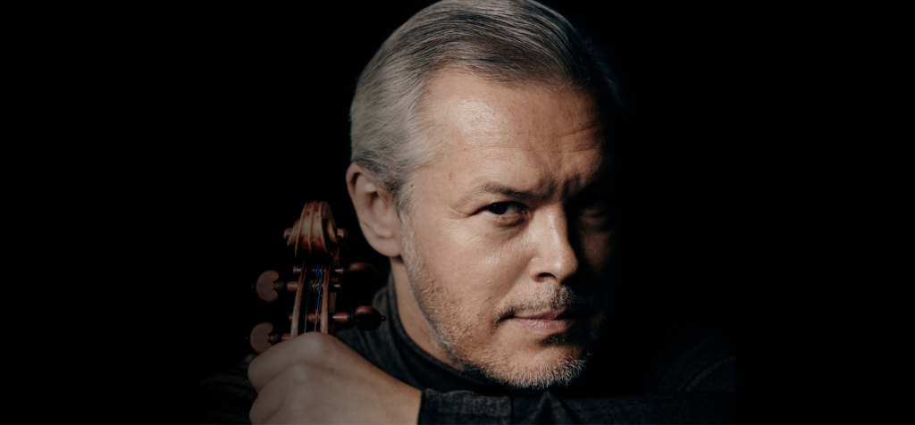 Ein Gesicht eines Mannes vor einem dunklen Hintergrund mit einer Violine an seiner Seite